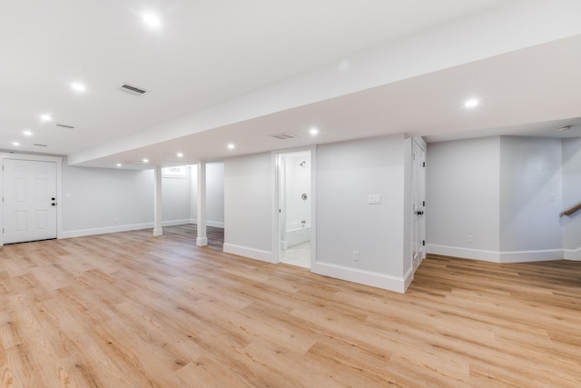 finished below grade area featuring recessed lighting, light wood-type flooring, visible vents, and baseboards