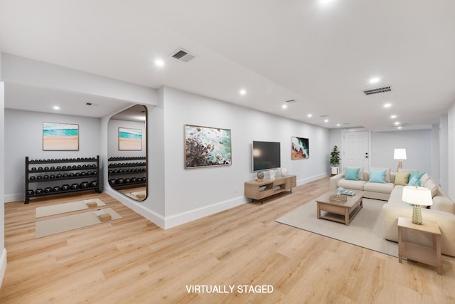 living room featuring baseboards, visible vents, wood finished floors, and recessed lighting