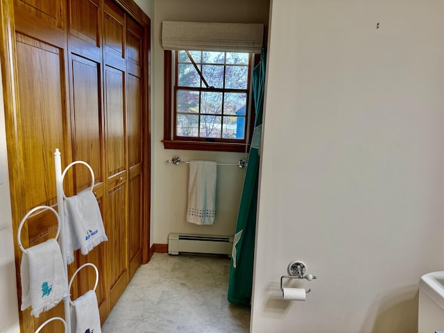bathroom with baseboards, a baseboard heating unit, and toilet