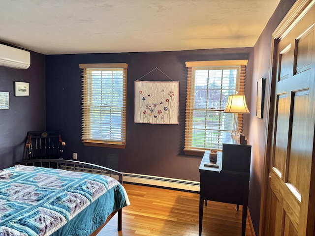 bedroom featuring baseboards, a wall unit AC, and wood finished floors