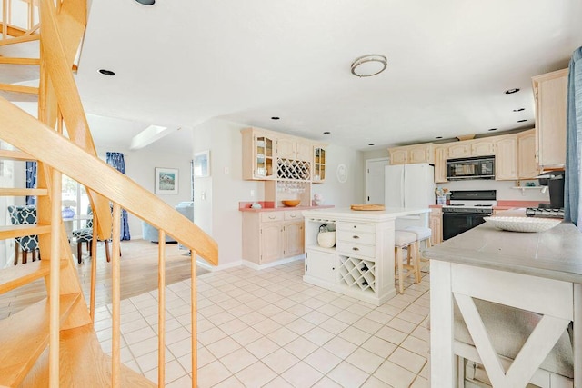 37 Old Salem Way, Osterville, MA 02655 - kitchen with black microwave, range with gas cooktop, light tile patterned floors, light countertops, and glass insert cabinets