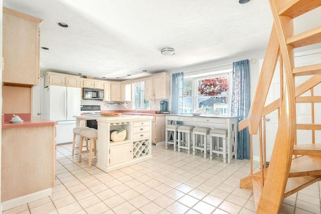 37 Old Salem Way, Osterville, MA 02655 - kitchen featuring black microwave, freestanding refrigerator, light countertops, light tile patterned floors, and recessed lighting