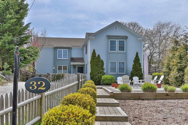 traditional home with fence and a patio