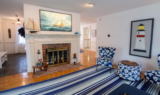 living room featuring a fireplace, wood finished floors, and baseboards