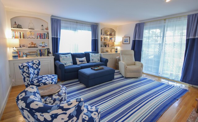 living area featuring light wood-style flooring and built in features