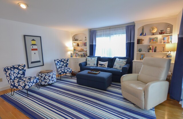 living room with built in shelves and wood finished floors