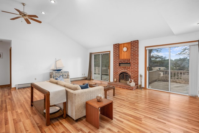 living room with a brick fireplace, a baseboard radiator, light hardwood / wood-style floors, and high vaulted ceiling