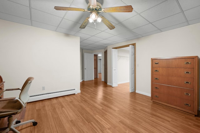 office space featuring a drop ceiling, a baseboard radiator, ceiling fan, and light wood-type flooring