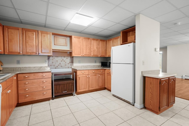 kitchen featuring a paneled ceiling, kitchen peninsula, and white fridge