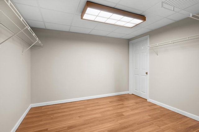 walk in closet featuring a paneled ceiling and light hardwood / wood-style floors