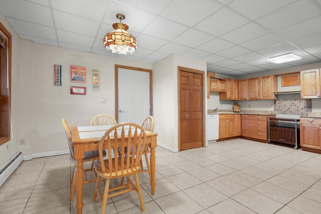 kitchen with baseboard heating, white dishwasher, light tile patterned flooring, a drop ceiling, and decorative light fixtures