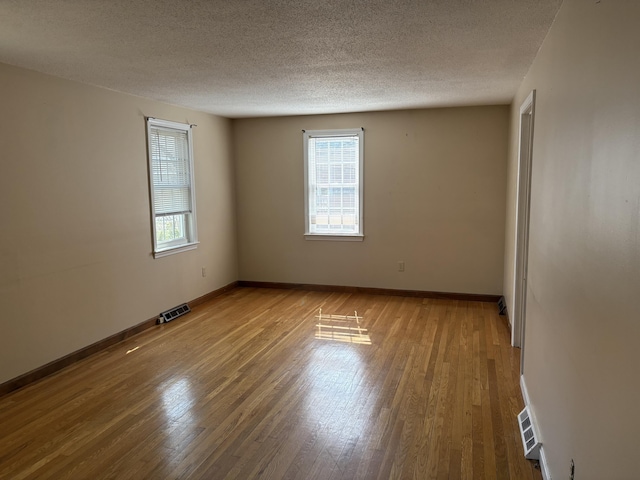 18 Russo Rd, West Yarmouth, MA 02673 - spare room featuring a textured ceiling, wood finished floors, baseboards, and visible vents