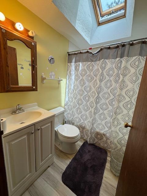 56 Wendward Way W, Yarmouth, MA 02673 - full bath with a skylight, wood finished floors, toilet, vanity, and curtained shower