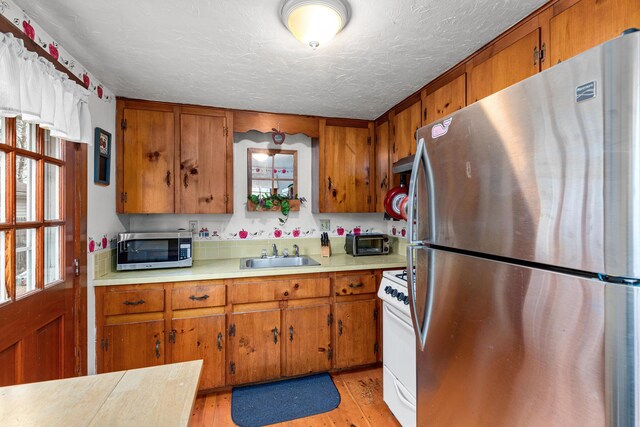 52 Nauset Rd, West Yarmouth, MA 02673 - kitchen with a sink, appliances with stainless steel finishes, and brown cabinetry
