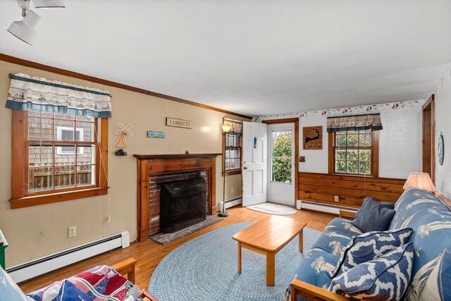 52 Nauset Rd, West Yarmouth, MA 02673 - living area with a baseboard heating unit, wood finished floors, and a fireplace