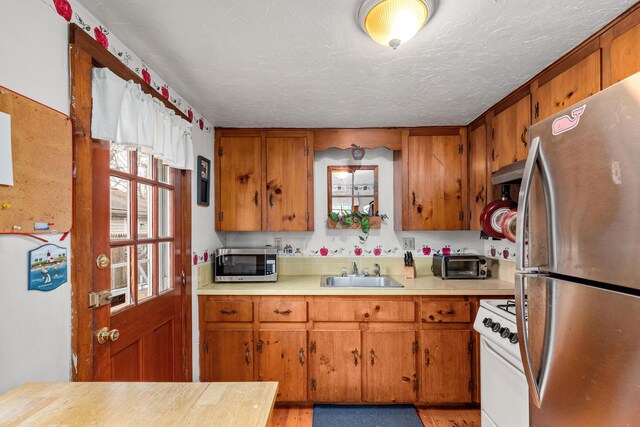 52 Nauset Rd, West Yarmouth, MA 02673 - kitchen featuring brown cabinets, appliances with stainless steel finishes, and a sink