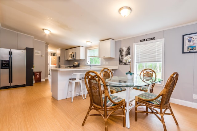 248 Mattapoisett Rd, Acushnet, MA 02743 - dining space featuring light wood-style floors, baseboards, and ornamental molding