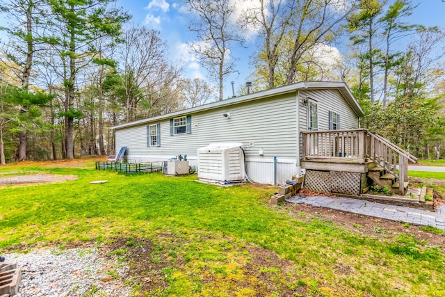 248 Mattapoisett Rd, Acushnet, MA 02743 - back of property with a lawn, a wooden deck, and central air condition unit