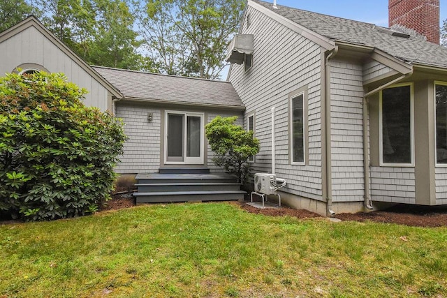 24 Indigo Ln, Osterville, MA 02655 - back of property featuring a shingled roof, a yard, and a chimney