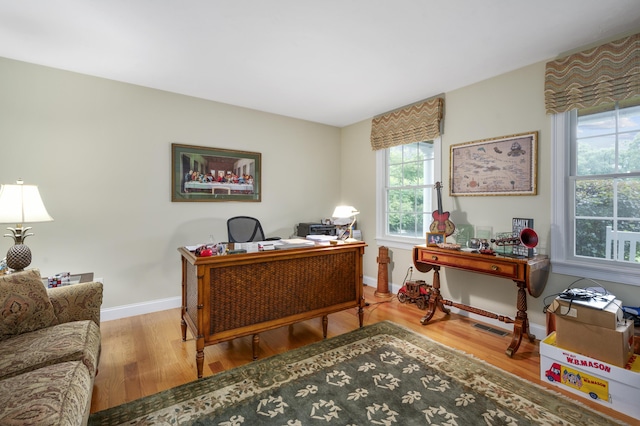office space featuring visible vents, baseboards, and wood finished floors
