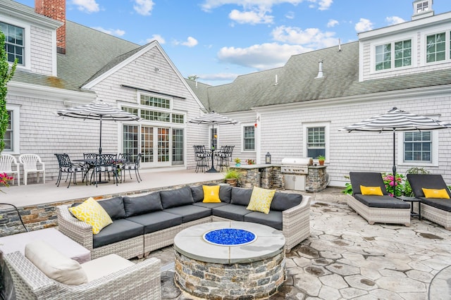 view of patio / terrace featuring an outdoor living space with a fire pit, an outdoor kitchen, and a grill