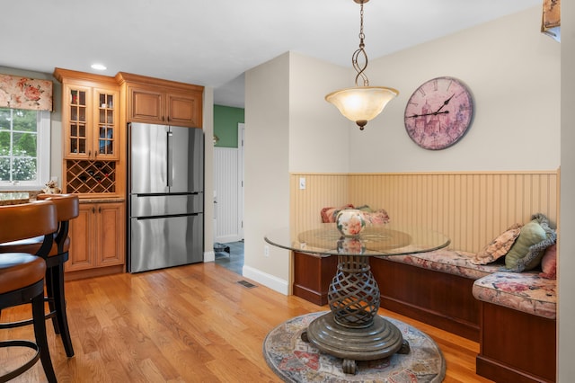 dining area featuring light wood-type flooring, visible vents, breakfast area, recessed lighting, and wainscoting