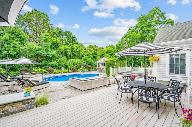 wooden deck with outdoor dining area and an outdoor pool