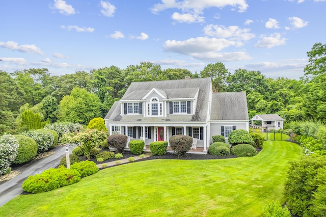 view of front facade featuring roof with shingles and a front lawn