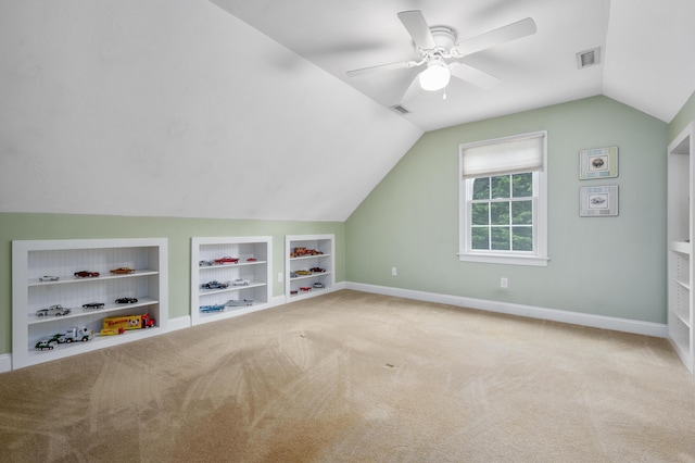 additional living space featuring visible vents, ceiling fan, baseboards, built in features, and lofted ceiling