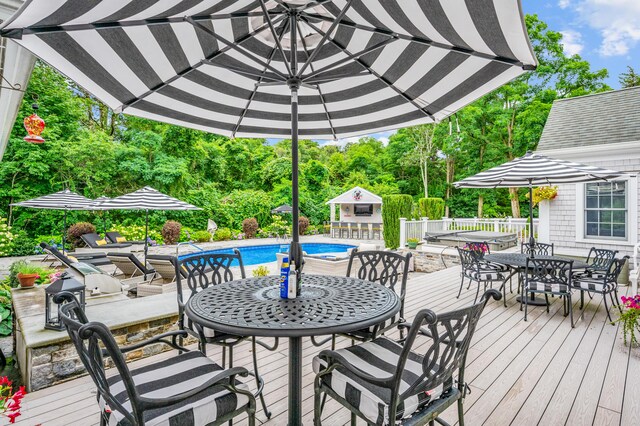 wooden terrace featuring an outdoor pool and outdoor dining space