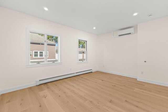 354 Gifford St Unit 1, Falmouth, MA 02540 - spare room with a baseboard radiator, an AC wall unit, light wood finished floors, baseboards, and recessed lighting