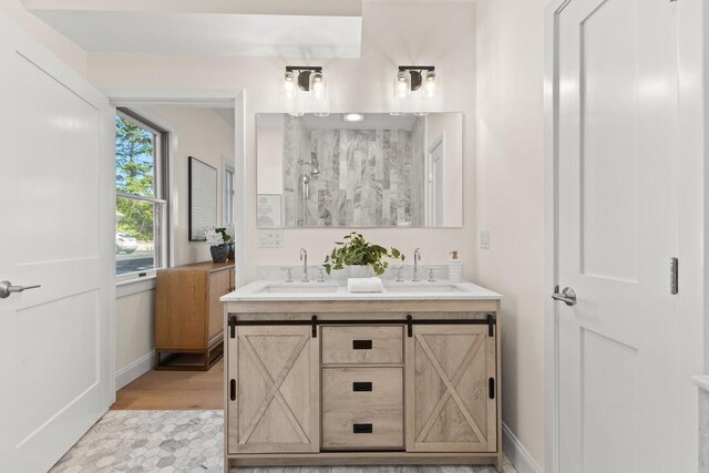 354 Gifford St Unit 1, Falmouth, MA 02540 - bathroom with walk in shower, baseboards, double vanity, and wood finished floors