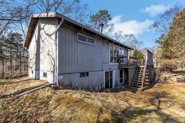 view of home's exterior featuring stairway and a wooden deck