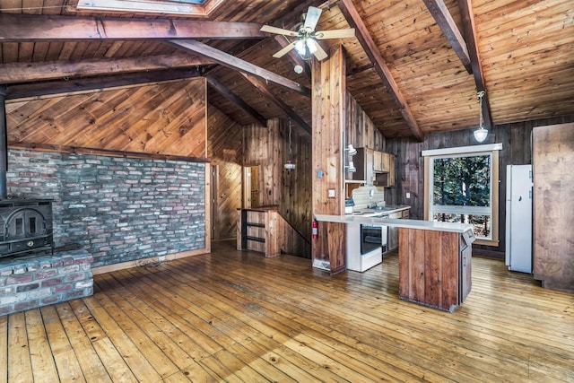 kitchen with white range with electric stovetop, a wood stove, light countertops, and light wood-style flooring