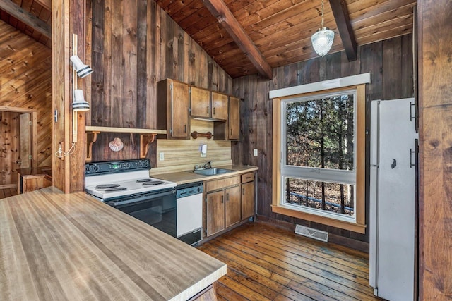 kitchen featuring white appliances, wood walls, wood ceiling, visible vents, and light countertops