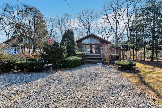 view of front of house featuring gravel driveway and a deck