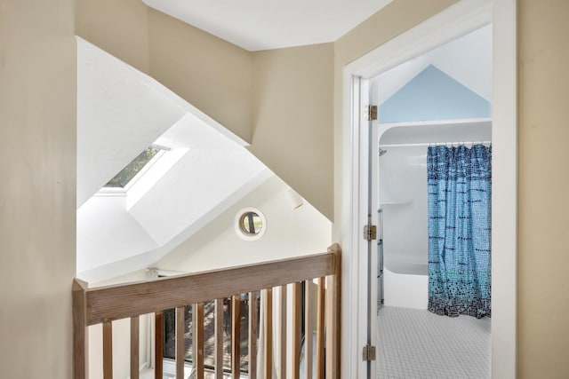 corridor featuring a skylight and tile patterned floors