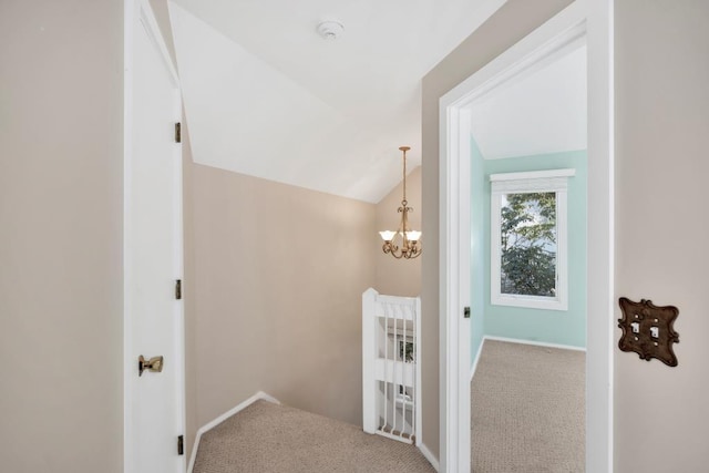 stairs with a notable chandelier, carpet, and lofted ceiling