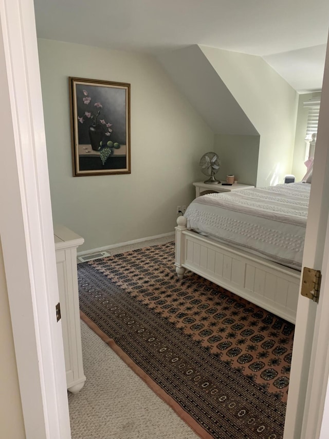 carpeted bedroom featuring lofted ceiling