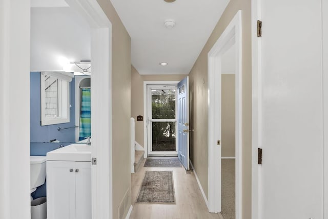 entryway featuring sink and light hardwood / wood-style flooring