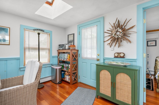 16 Gulls Cove Rd, West Yarmouth, MA 02673 - office featuring a skylight, wainscoting, wood finished floors, a baseboard radiator, and a decorative wall
