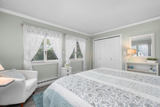 bedroom with dark wood-style flooring, ornamental molding, baseboard heating, and a closet