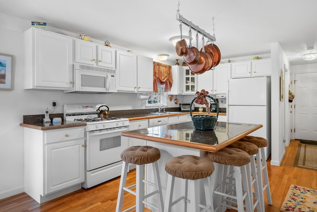 kitchen with white appliances, white cabinets, and a kitchen island