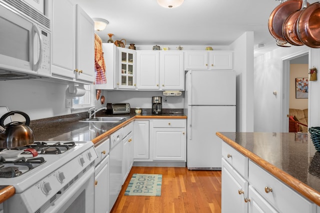 kitchen with sink, white appliances, white cabinetry, and light hardwood / wood-style flooring