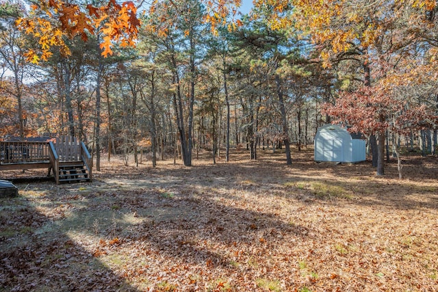 view of yard featuring a deck and a storage unit