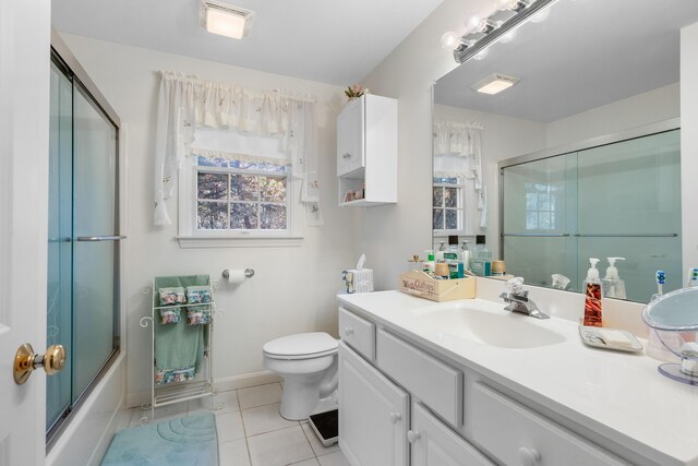 full bathroom featuring bath / shower combo with glass door, toilet, tile patterned floors, and vanity