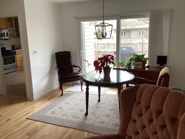 dining area featuring light hardwood / wood-style flooring and a notable chandelier