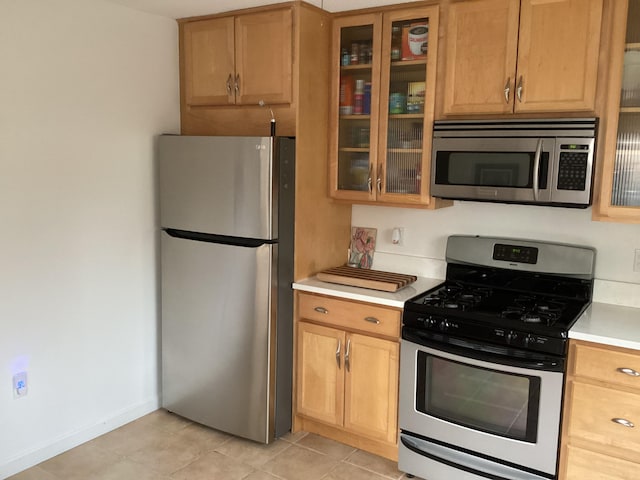 kitchen with stainless steel appliances and light tile patterned flooring