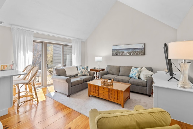 living area featuring light wood-style flooring and high vaulted ceiling
