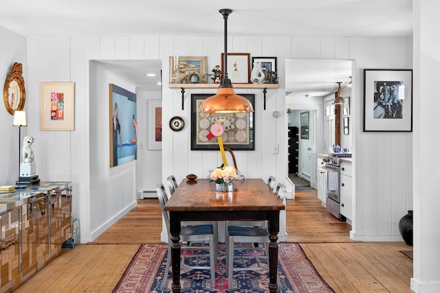 7 Anthony St, Provincetown, MA 02657 - dining room featuring light wood finished floors, a decorative wall, and a baseboard heating unit